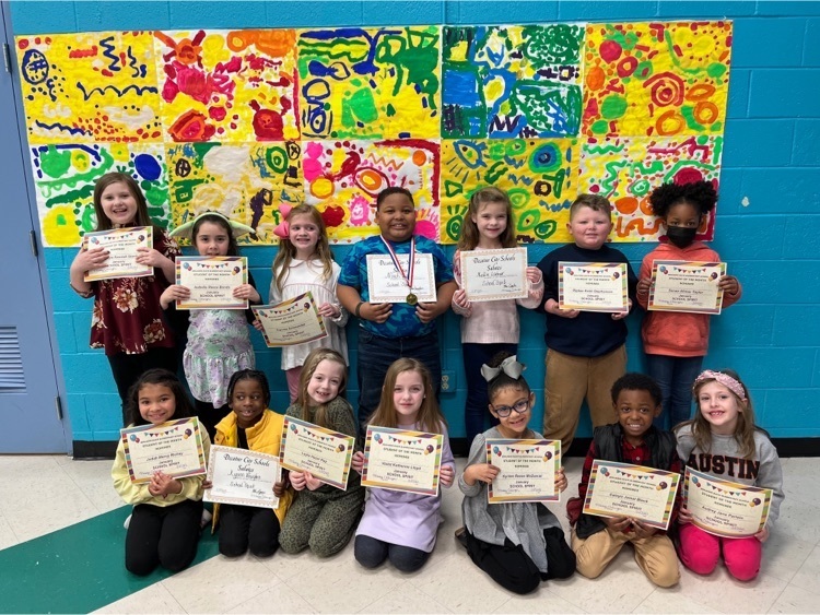 Fourteen students are posed with their certificates for Student of the Month in the category of School Spirit. 