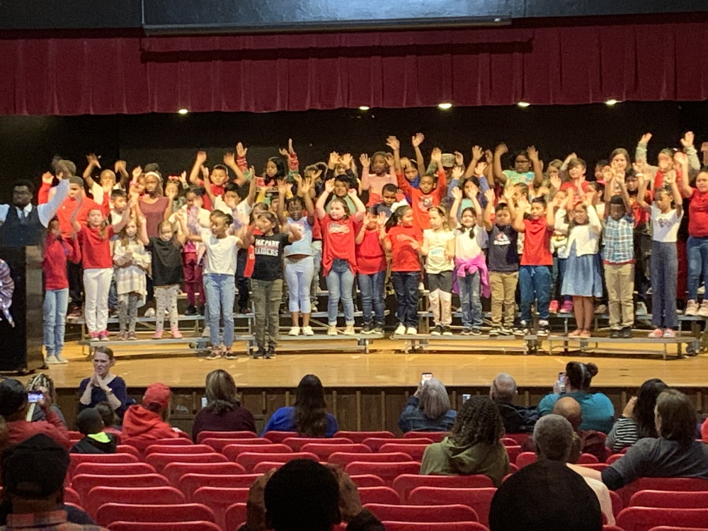 Students singing on stage Veterans Day Program