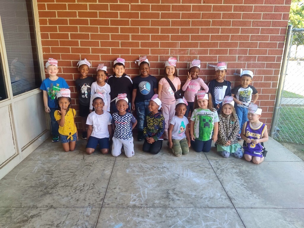 group picture of students wearing paper hats