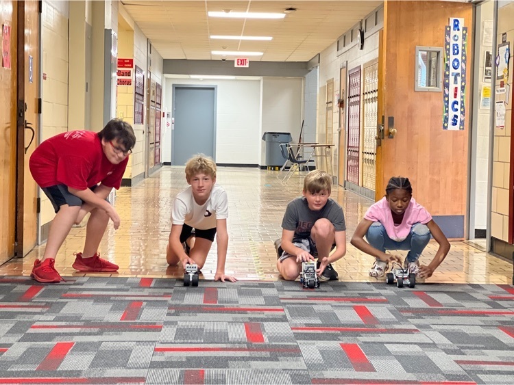 Students doing Robotics testing in the hallway on the carpet